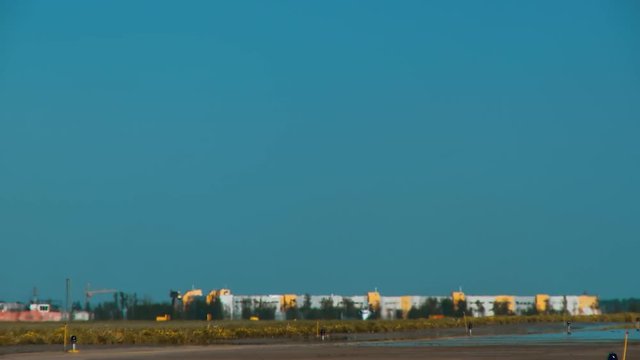 Small business jet takes off from the runway and leaves into the blue sky. The picture is distorted by the rising hot air