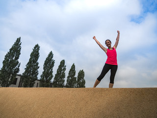 triumphant Fitness WOMAN standing IN YES POSE and making fists after workout