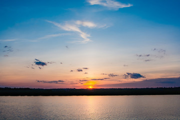 Sunset in the lake. beautiful sunset behind the clouds above the over lake landscape background. dramatic sky with cloud at sunset