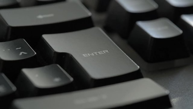 Enter Key, keyboard. Macro shot of finger pressing Enter