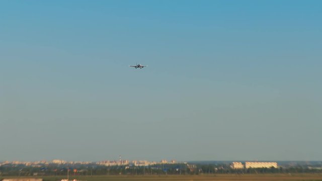 Landing aircraft on the background of the whole Pulkovo airport. We see the airport building, cars of passengers and people meeting, transportation of technical services and a pond