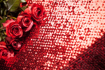 scarlet roses on the table of sequins
