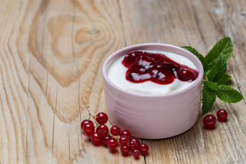 Rote Grütze mit Johannisbeeren in einer Schale auf Holzuntergrund