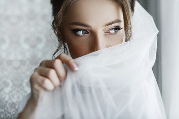 Morning preparations. Gorgeous bride in white luxury dress is getting ready for wedding.