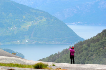A photographer taking picture of Husedalen valley, Kinsarvik, Norway