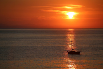 Fototapeta na wymiar Ship in the sea on the sunrise near the coast