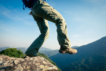 successful hiker stand on sunrise mountain top cliff edge