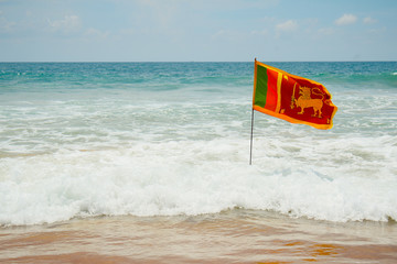 Obraz premium Flag waving on the coast beach / National symbol of Sri Lanka island