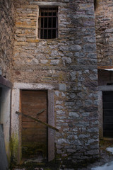 Fototapeta na wymiar A door in an abandoned building in the hill village of Casso in winter Friuli Venezia Giulia, north east Italy. 