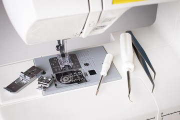 Repair Of Sewing Machine. White Sewing Machine With Tools Of Screwdriver, Tweezers Top View.