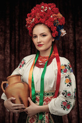 Portrait of attractive woman standing in traditional Slavic costume,  wearing embroidered blouse,...
