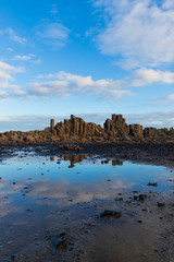 Water puddle and rock columns at Bombo Quarry, NSW.