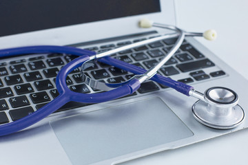Stethoscope lying on a laptop keyboard in a concept of online m