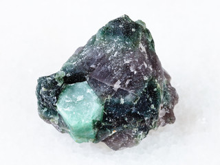 rough crystal of Beryl gemstone in rock on white