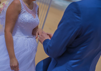 To be married couple exchanging rings while being married at beautiful beach.