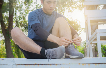 Athlete tying laces for jogging on road in minimalist barefoot running shoes.