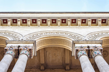 View from bottom to old museum arches with ornaments.