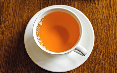 Black tea in a white cup on dish