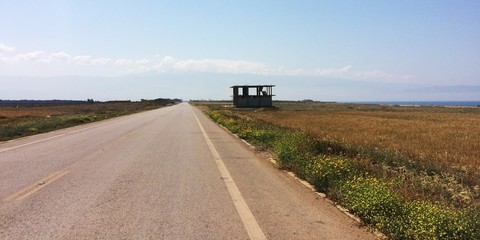 straight road with the white summits of Mount Lebanon in background