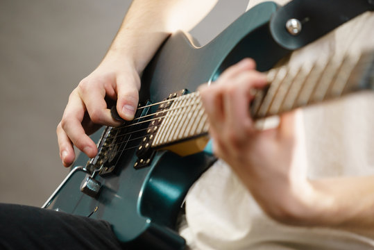 Close up of man playing on electric guitar