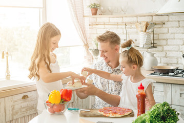 dad with daughters preparing pizza