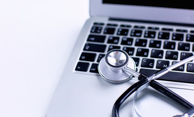 Stethoscope lying on a laptop keyboard in a concept of online m