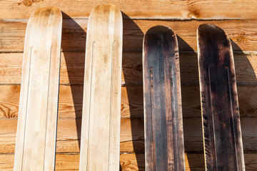 wide forest skis near wooden wall of country house