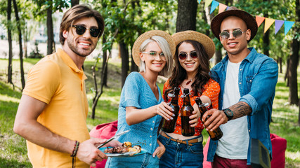 portrait of young multiethnic friends having barbecue in summer park