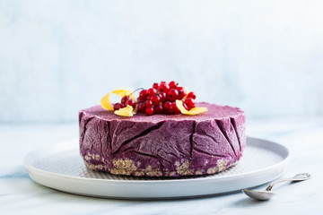 frozen blueberry lemon cake from ice cream and fresh berries on a cake stand on a marble table. summer festive dessert