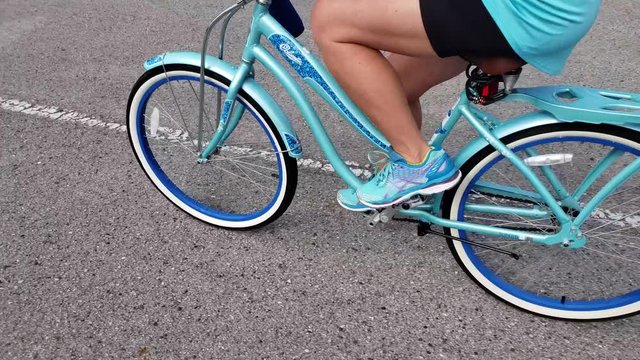 Lady riding on a bicycle with matching colored clothes.