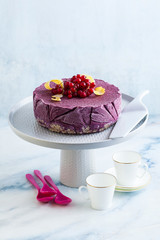frozen blueberry lemon cake from ice cream and fresh berries on a cake stand on a marble table. summer festive dessert