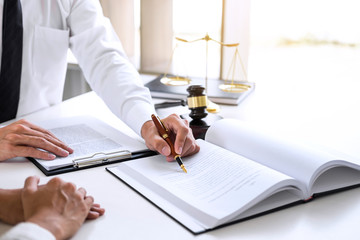 Businesspeople or lawyer having team meeting discussing agreement contract documents, judge gavel with Justice lawyers at law firm in background, Legal law, advice and justice concept