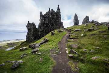 A dirt path to the Old Man of Storr on the Isle of Skye with a sea in the background during a cloudy summer day in Scotland