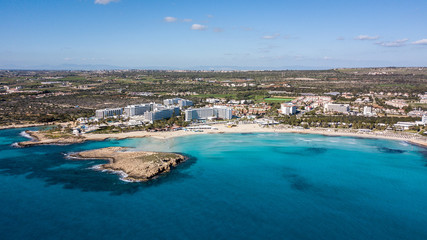 aerial view of touristic town on seashore with blue sky and sea, Cyprus