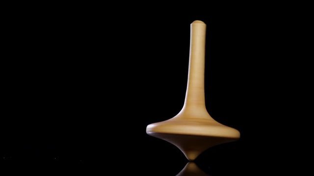 Close up shot of a wooden spinning top moving.
