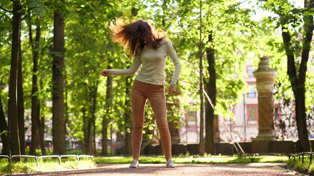 Woman dancing and jumping in street, flying hair flatter and flip in air
