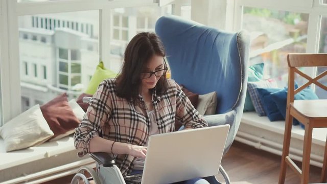 Disabled woman in wheelchair with laptop.Slow mo