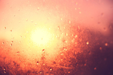 Blurred texture. Sunset after the rain through the glass with droplets, golden sunset.