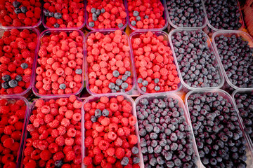 Berry fruits in baskets at a marketplace. mixed berries at eco market