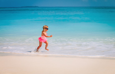 Fototapeta na wymiar little girl run play with waves on beach