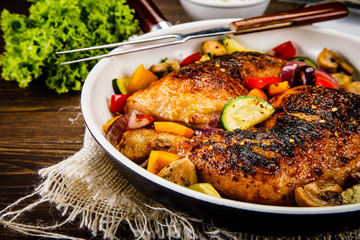 Roast chicken legs served on frying pan