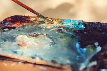 Artist's palette, close-up. Background image of bright oil-paint palette closeup. Workplace painter...