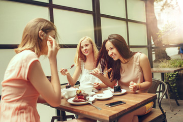 Two girl friends spend time together drinking coffee in the cafe, having breakfast and dessert.