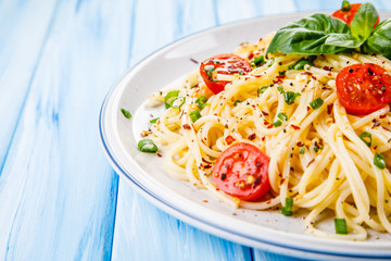 Pasta with vegetables on wooden table
