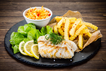 Fish dish - fried fish fillet with french fries and vegetables