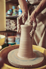 Creating a jar or vase of white clay close-up. Master crock. Man hands making clay jug macro.