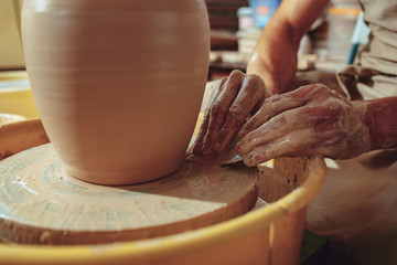Creating a jar or vase of white clay close-up. Master crock. Man hands making clay jug macro.