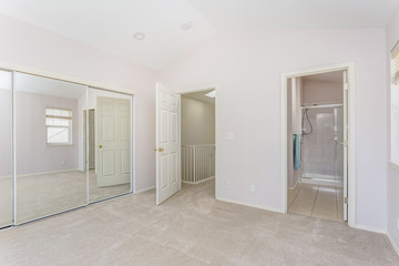 Empty light filled bedroom with vaulted ceiling.
