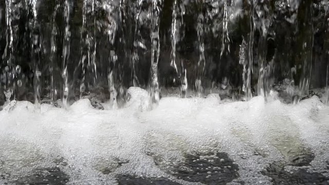 Small waterfall on the River Rea.

Water falling over a weir close up. Shot in slow motion.