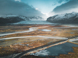 Vatnajokull glacier aerial drone image with street highway and clouds and blue sky. Dramatic winter scene of Vatnajokull National Park, Iceland, Europe. Beauty of nature concept background.